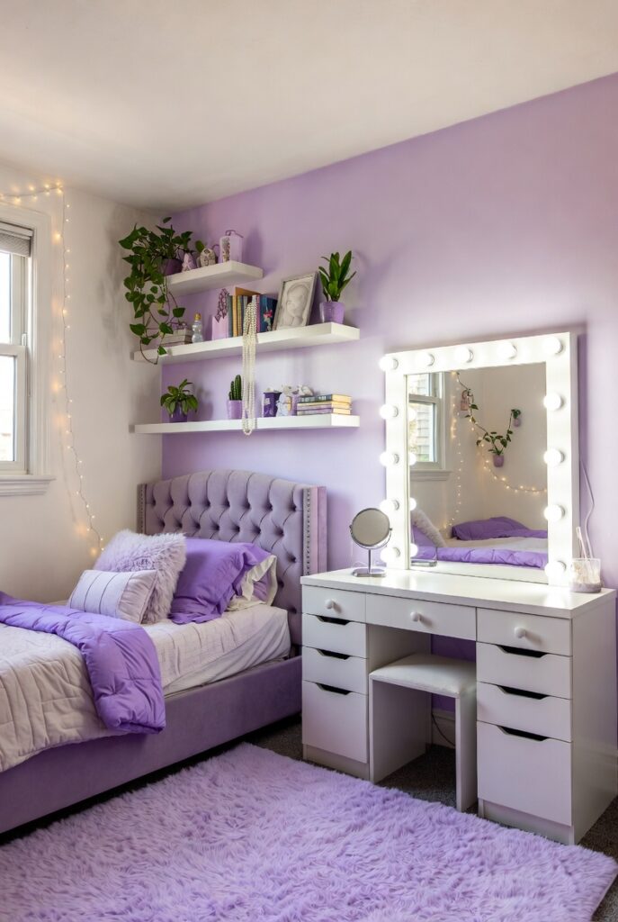 Elegant teen bedroom in lavender with tufted bed, floating shelves, and layered bedding.